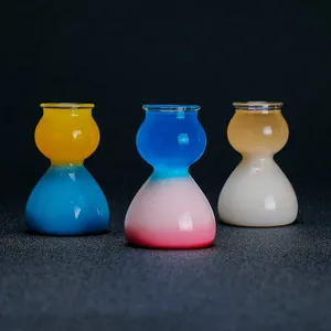Primer plano de vasos de chupito de cristal con forma de calabaza y gradientes vivos