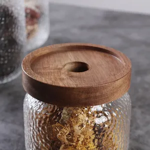 Nahaufnahme eines Vorratsglases mit Hammerschlag-Optik und Holzdeckel mit Loch