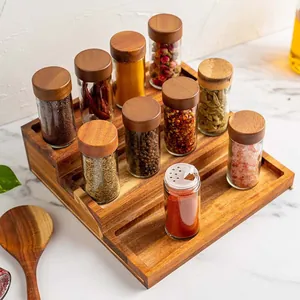 Close-up of glass spice jars with acacia wood lids on a 3-tier wooden rack