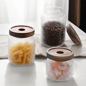 Detailansicht von gehämmerte Vorratsgläsern aus Glas mit Holzdeckeln für die Küche.