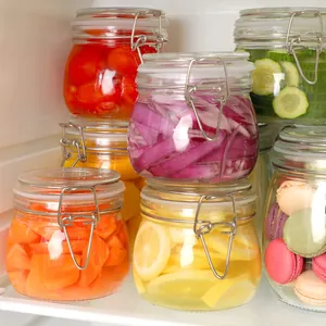 Detailed view of glass storage jars with airtight seals for refrigerator food organization.