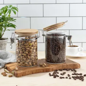 Detail view of airtight glass storage jars with bamboo lids for coffee beans and pistachios