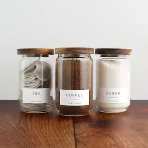 Détail de trois bocaux en verre avec couvercles en acacia pour thé, café et sucre