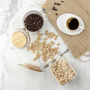 Set of airtight borosilicate glass storage jars with bamboo lids on marble surface
