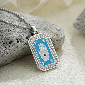 Macro view of a blue Hamsa Hand and Evil Eye tarot style pendant with clear rhinestones
