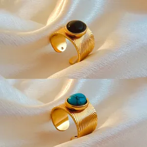 Close-up of retro 18K gold-plated rings with black and turquoise oval stones