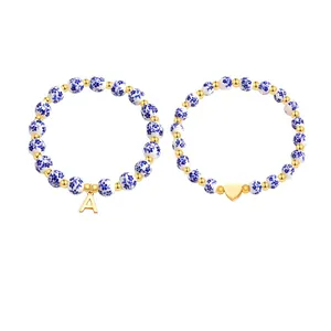 Elegant blue and white porcelain bead bracelet set with gold heart and initial letter charms