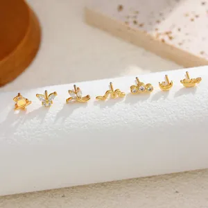 Detail view of gold plated stainless steel ear studs with various designs and zirconia.