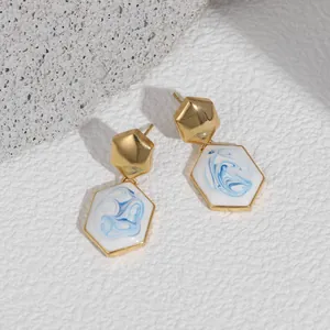 Detailed macro view of 18K gold-plated hexagonal earrings with blue marble enamel finish