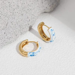 Detailed view of the blue and white porcelain enamel finish on these 18K gold hoop earrings