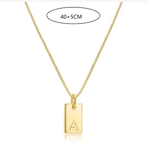 Detail of gold stainless steel necklace featuring engraved initial A on a square pendant