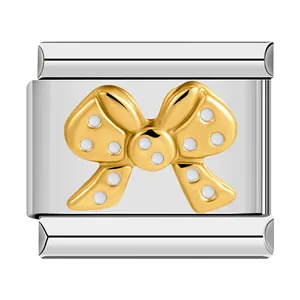 Detailed macro view of a golden bow tie motif on a stainless steel Italian modular charm link.