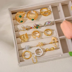 Collection of minimalist 18K gold rings with irregular shapes in a jewelry tray.
