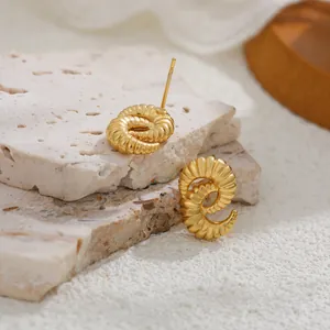 Primer plano de pendientes de tuerca con textura espiral dorada y baño de oro de 18K