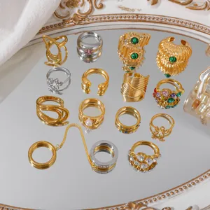 Collection of vintage 18K gold minimalist rings on an ornate mirrored tray display