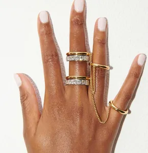 Close-up of elegant gold and crystal multi-finger rings with connecting chain detail.