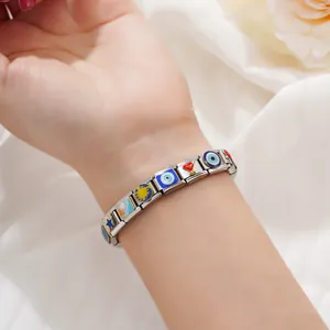 Close-up of stainless steel Italian modular charm bracelet with evil eye motifs