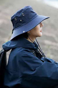 Profilo laterale di un uomo che indossa un cappello da pescatore blu navy ad asciugatura rapida.