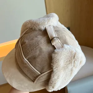 Close-up detail of khaki corduroy trapper hat with soft white plush lining and buckle