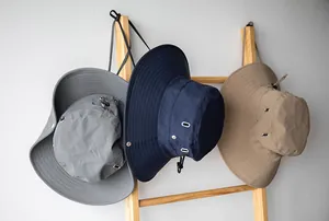 Tre cappelli da sole outdoor a tesa larga ad asciugatura rapida appesi a una scala