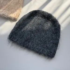 Close-up of dark grey fuzzy knit beanie showing soft mohair-style winter texture.