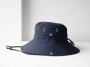 Vista dettagliata del cappello da sole blu navy con occhielli e bottoni a pressione