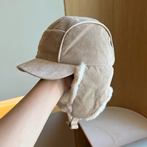 Detail of corduroy trapper hat with soft white plush lining and protective ear flaps