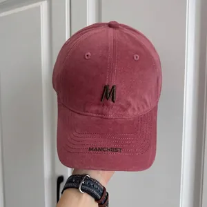 Detalle gorra de béisbol vintage rosa con bordado letra M marrón y diseño de copa suave