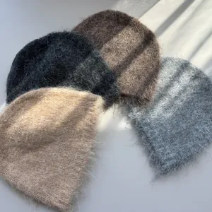 A selection of soft fuzzy mohair-style beanies in various neutral colors for winter