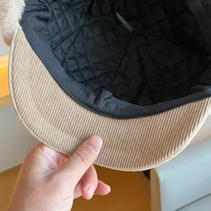 Close-up detail of the black quilted lining and corduroy brim of the winter trapper hat