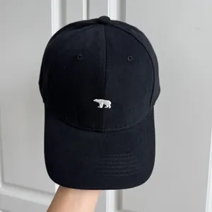 Vue détaillée de face d'une casquette de baseball noire avec broderie d'ours polaire.