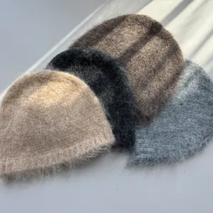Detailed view of four fuzzy winter beanie hats in beige, black, brown, and grey