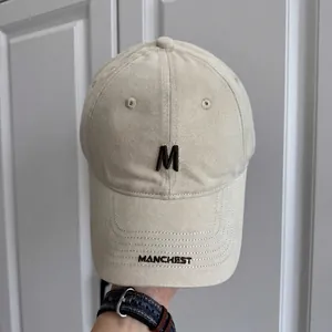 Vista detallada de una gorra de béisbol vintage beige con el bordado M y Manchest