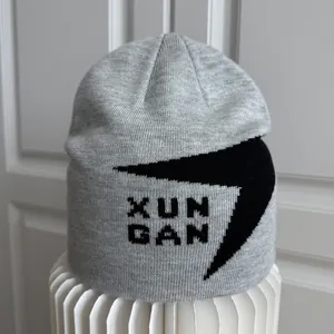 Detalle de gorro de punto gris con diseño gráfico negro XUNGAN para deporte fuera