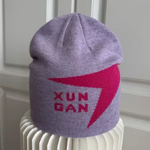 Detalle del gorro de punto lavanda con gráfico magenta y patrón de texto XUN GAN.