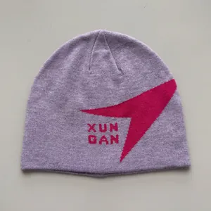 Primer plano de un gorro de punto lavanda con el diseño gráfico XUN GAN en magenta