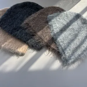 Detailed view of soft fuzzy winter beanies in beige, black, brown and grey colors