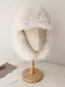 Vista detallada de un gorro ruso de piel sintética crema en un maniquí de madera.