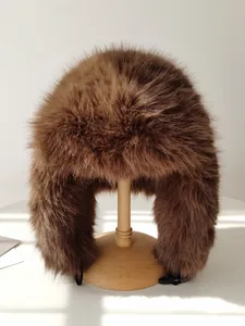Gorro Ushanka de piel sintética marrón con orejeras sobre soporte de madera