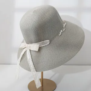 Elegant grey wide-brim straw sun hat with delicate white lace bow and pearl trim