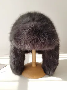 Detalle macro de gorro Ushanka de piel sintética gris sobre soporte de madera