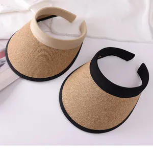 Close-up detail of women's open top straw sun visors in black and beige finishes
