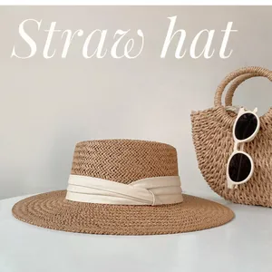 Elegant wide-brim straw hat with cream ribbon detail for beach sun protection and summer style