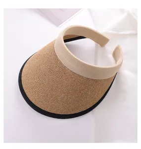 Close-up of a woven straw visor hat with cream headband and black trim