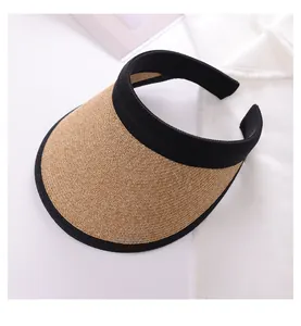 Close-up detail of a women's wide brim straw sun visor hat with a black elastic headband