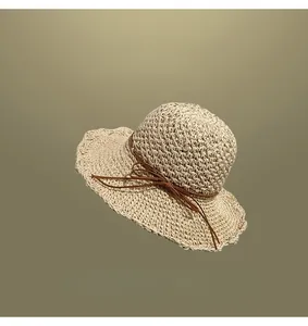 Detailed view of a handmade woven straw sun hat featuring a decorative brown bow