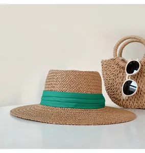 Detailed view of a summer straw hat featuring a flat top and a vibrant green decorative ribbon