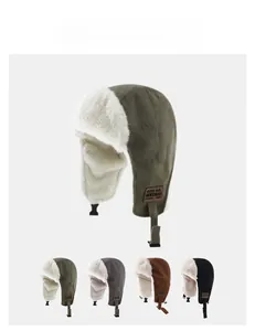 Detail view of plush trapper hats with ear flaps in green, grey, brown, and black.