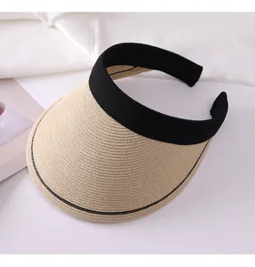Detail view of a women's straw sun visor featuring a wide brim and black headband