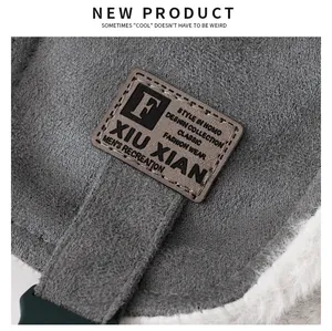 Close-up detail view of a grey trapper hat featuring a stylish patch and warm fleece lining